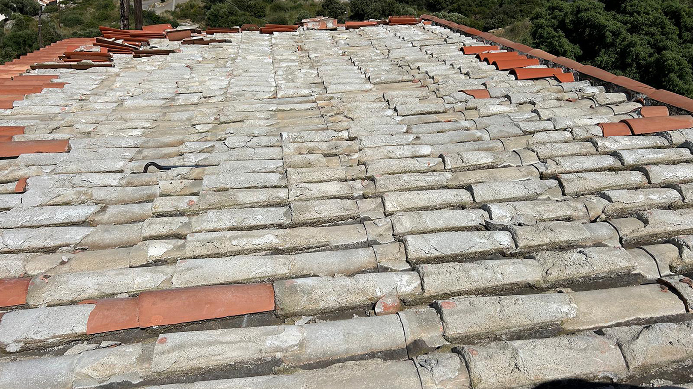 Dépose partielle du toit, montrant l'ancienne couche de mortier sous les tuiles.